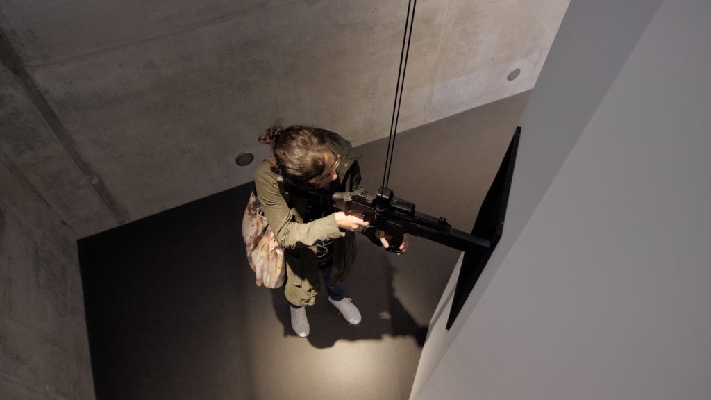 Ein G36 Maschinengewehr von Heckler und Koch in den Händen der documenta Besucher*innen