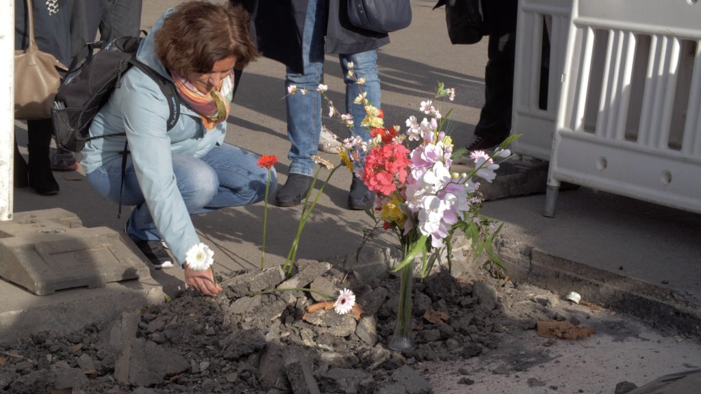 Aus Respekt vor den Toten von Flucht und Vertreibung legen Bürgerinnen Blumen am ehemaligen Standort des Obelisken nieder 